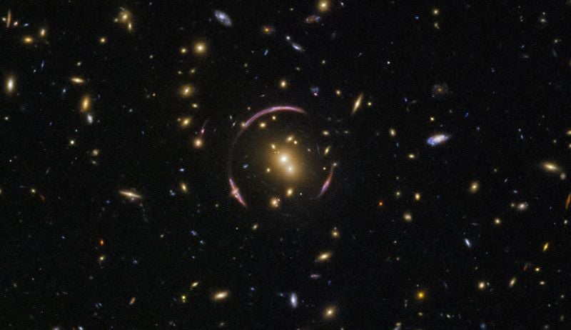 Скопление галактик SDSSJ0146-0929 достаточно массивно для того, чтобы сильно исказить окружающее пространство. Видна масса звезд и газа в каждой галактике, однако тёмная материя увеличивает массу этого скопления. Источник изображения: NASA